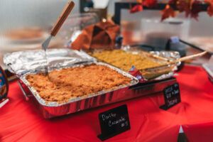 A spread of Thanksgiving favorites, including our best overall dish, Dorito Casserole, roast turkey, gravy, and cranberry sauce, set up on a table for the office potluck celebration.